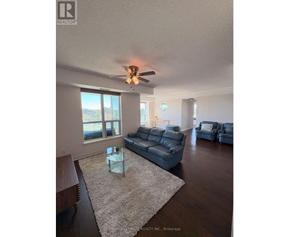 A living room with a grey couch and a glass coffee table.