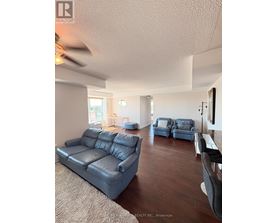 A living room with a large couch and a smaller chair.