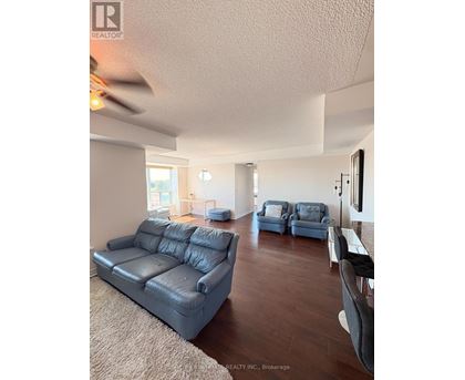 A living room with a large couch and a smaller chair.