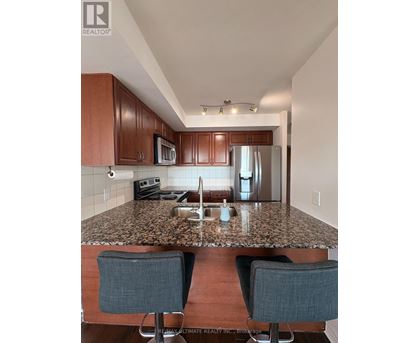 A kitchen with brown cabinets and granite countertops.