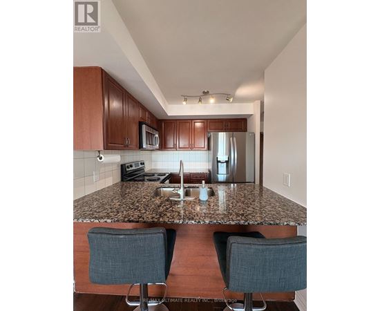 A kitchen with brown cabinets and granite countertops.