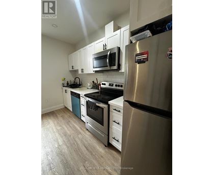 A modern kitchen with stainless steel appliances and white cabinets.