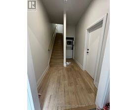 A hallway with wooden floors and white walls.