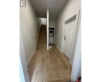 A hallway with wooden floors and white walls.