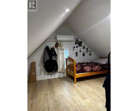 A bedroom with a bed, a wardrobe, and a window.