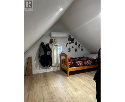 A bedroom with a bed, a wardrobe, and a window.