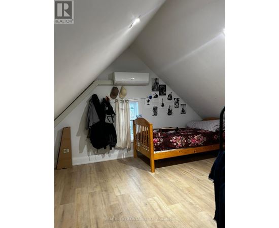 A bedroom with a bed, a wardrobe, and a window.