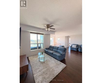 A living room with a grey couch and a glass coffee table.