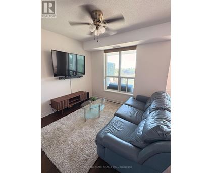 A living room with a grey couch and a flat screen TV.