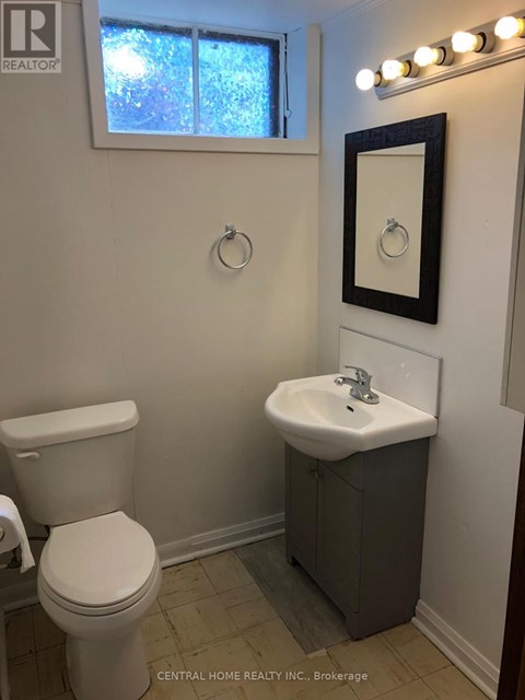 A white toilet sits next to a sink in a small bathroom.