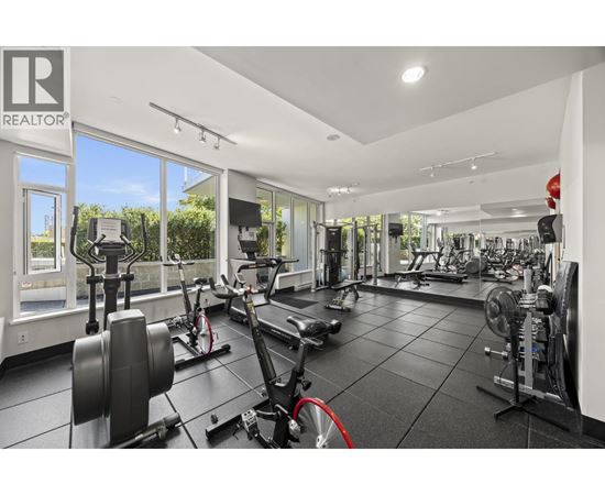 A gym with a variety of equipment including treadmills, weights, and exercise bikes.