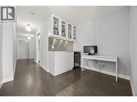 A living room with a television and a cabinet with glass doors.