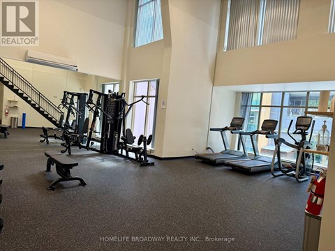 A gym with a variety of equipment including treadmills, weights, and a bench.