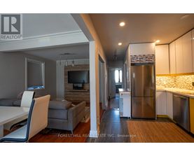 A kitchen with a refrigerator, stove, and sink.