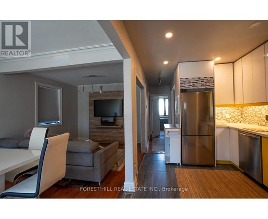 A kitchen with a refrigerator, stove, and sink.
