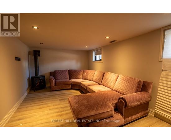 A living room with a brown sofa and a wood burning stove.