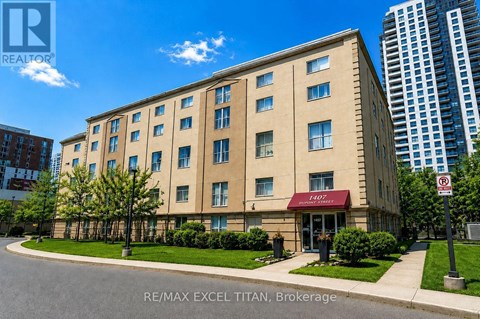 A building with the sign RE/MAX EXCEL TITAN, Brokerage in front of it.