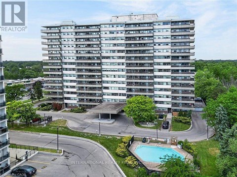 A large apartment building with a pool in the courtyard.