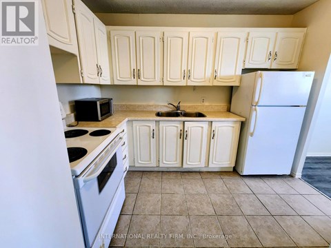 A kitchen with white cabinets and appliances.
