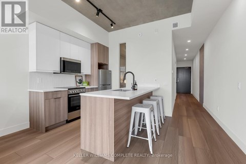 A modern kitchen with white cabinets and a wooden island.
