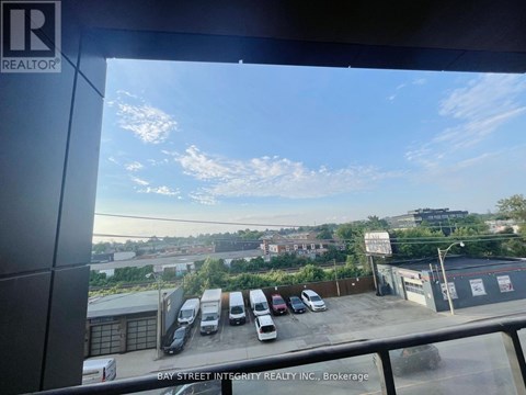 A parking lot with several cars and a building in the background.