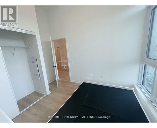 A room with a black mat on the floor and a door in the background.
