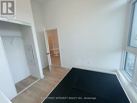 A room with a black mat on the floor and a door in the background.