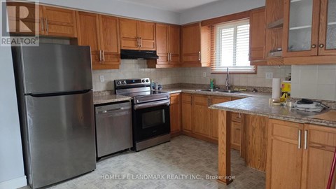 A kitchen with wooden cabinets and a stainless steel refrigerator.