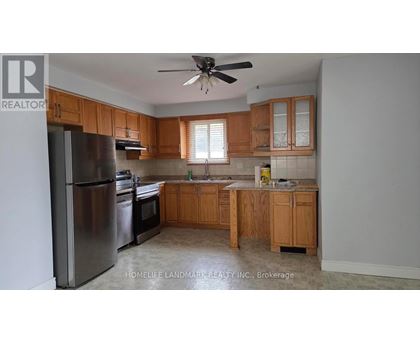 A kitchen with wooden cabinets and a stainless steel refrigerator.