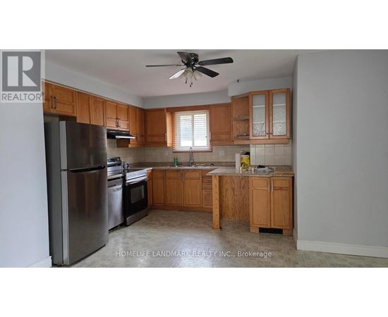 A kitchen with wooden cabinets and a stainless steel refrigerator.