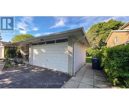 A white garage door is closed and the house is white.