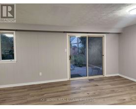 A room with a sliding glass door leading to a backyard.