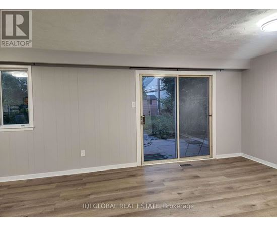 A room with a sliding glass door leading to a backyard.