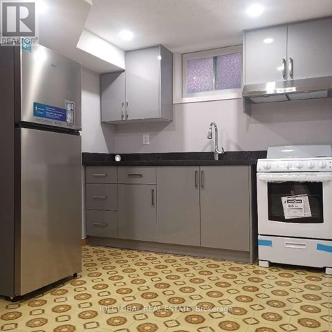 A kitchen with a refrigerator, oven, and cabinets.