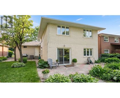 A house with a brick exterior and a patio area with a table and chairs.