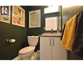 A bathroom with a toilet, sink, and a mirror.