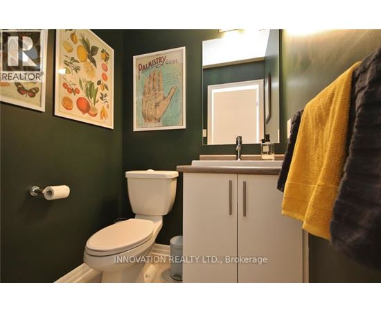 A bathroom with a toilet, sink, and a mirror.