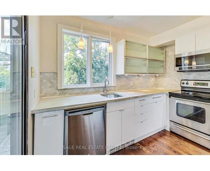 A modern kitchen with white cabinets and stainless steel appliances.