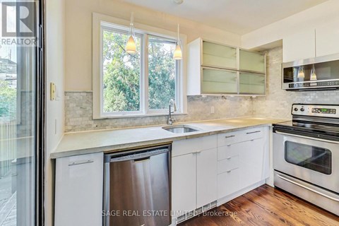 A modern kitchen with white cabinets and stainless steel appliances.
