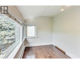A room with a window and a view of trees outside.