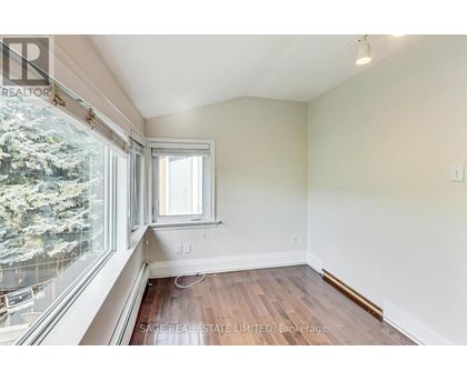 A room with a window and a view of trees outside.