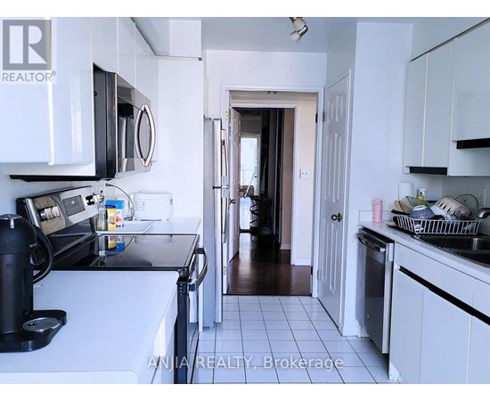 A kitchen with white cabinets and a black coffee maker.