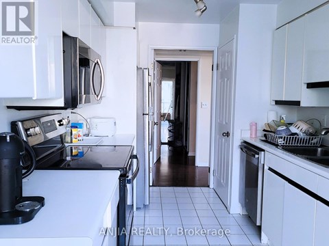 A kitchen with white cabinets and a black coffee maker.