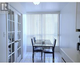 A dining room with a table and chairs.