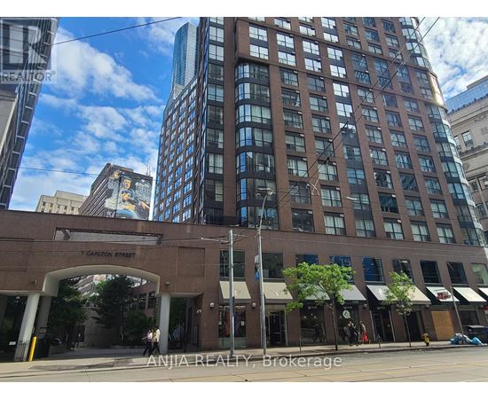 A street view of Carlton Street with a building in the foreground and a clear blue sky above.
