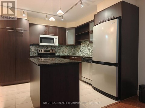 A kitchen with a white fridge and a black counter top.