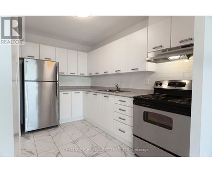 A kitchen with white cabinets and a stainless steel refrigerator.