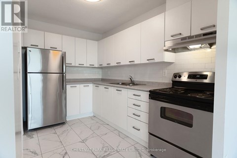 A kitchen with white cabinets and a stainless steel refrigerator.