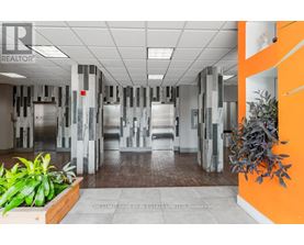 A hallway with a plant on the left and a plant on the right.