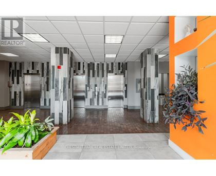 A hallway with a plant on the left and a plant on the right.